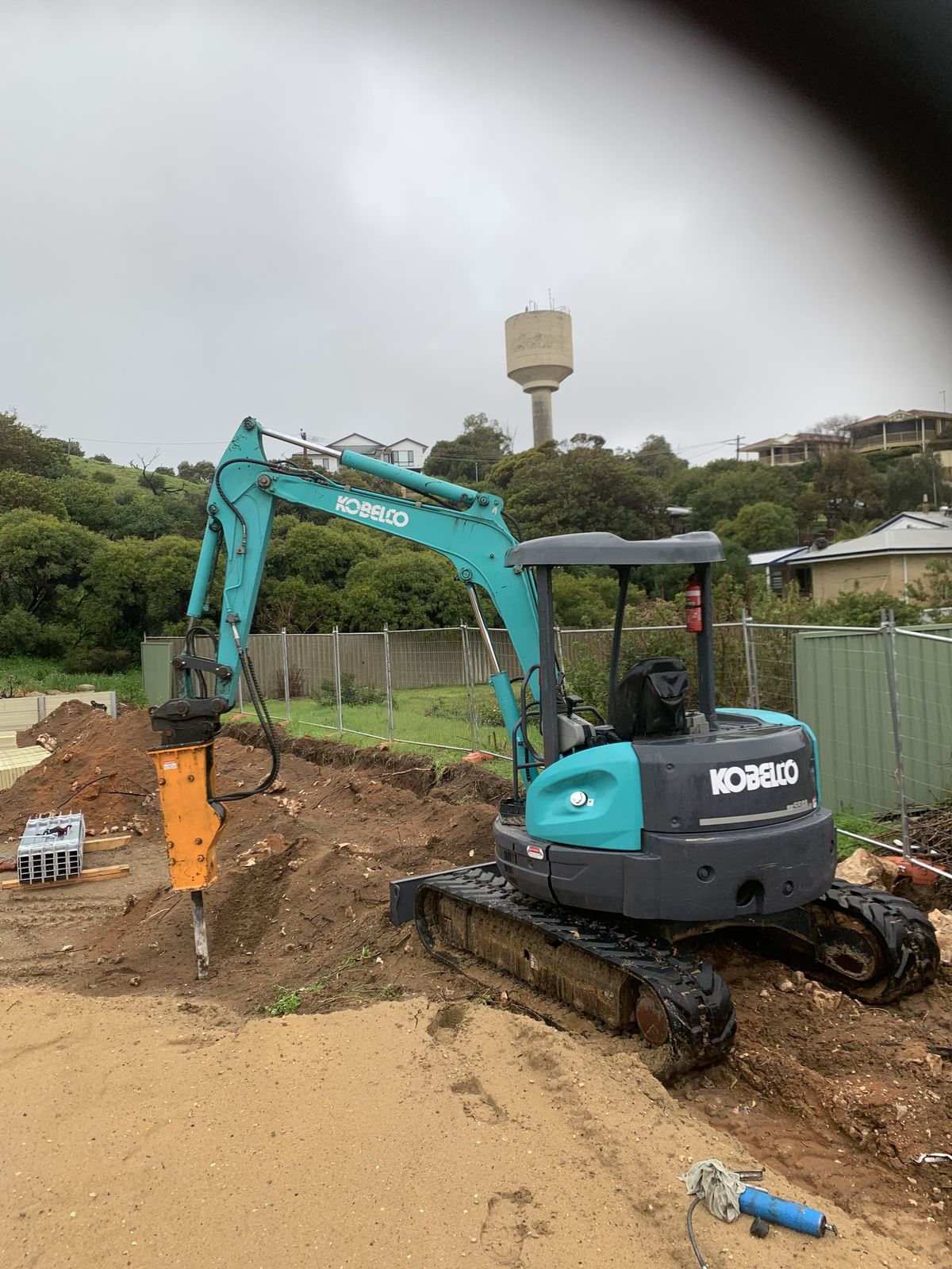 Professional Kobelco excavator with rock breaker attachment performing excavation work in Mandurah, Western Australia